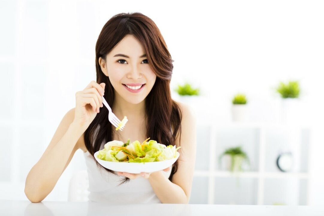 Den japanske kvinnen spiser en salat